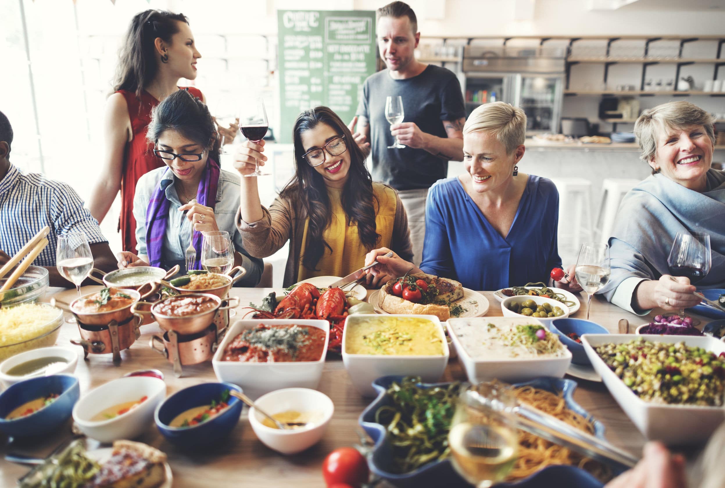 group of co-workers eating together with food display on table
